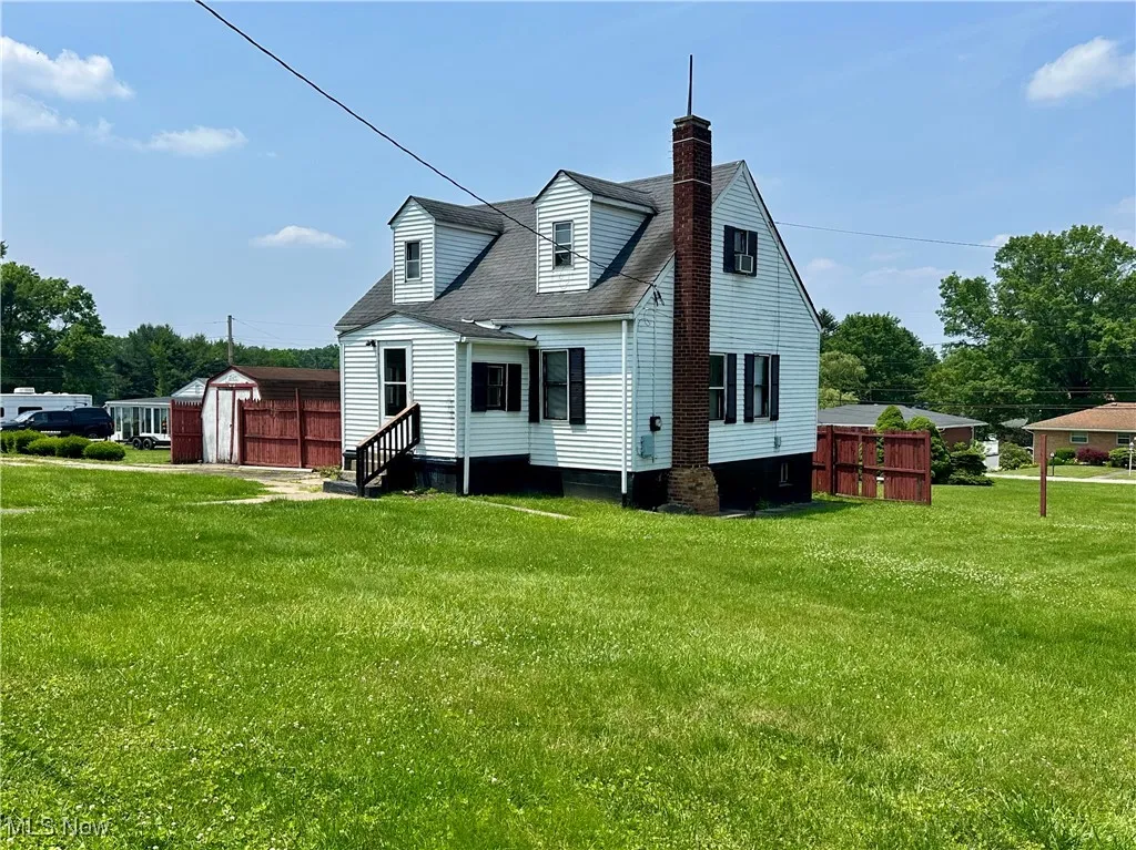 Front of home featuring a yard, and a shed