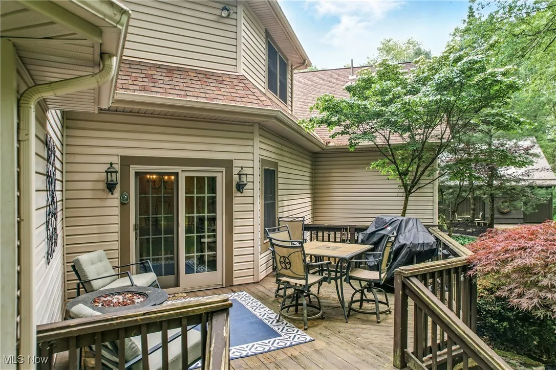 Wooden terrace with outdoor dining space and a fire pit