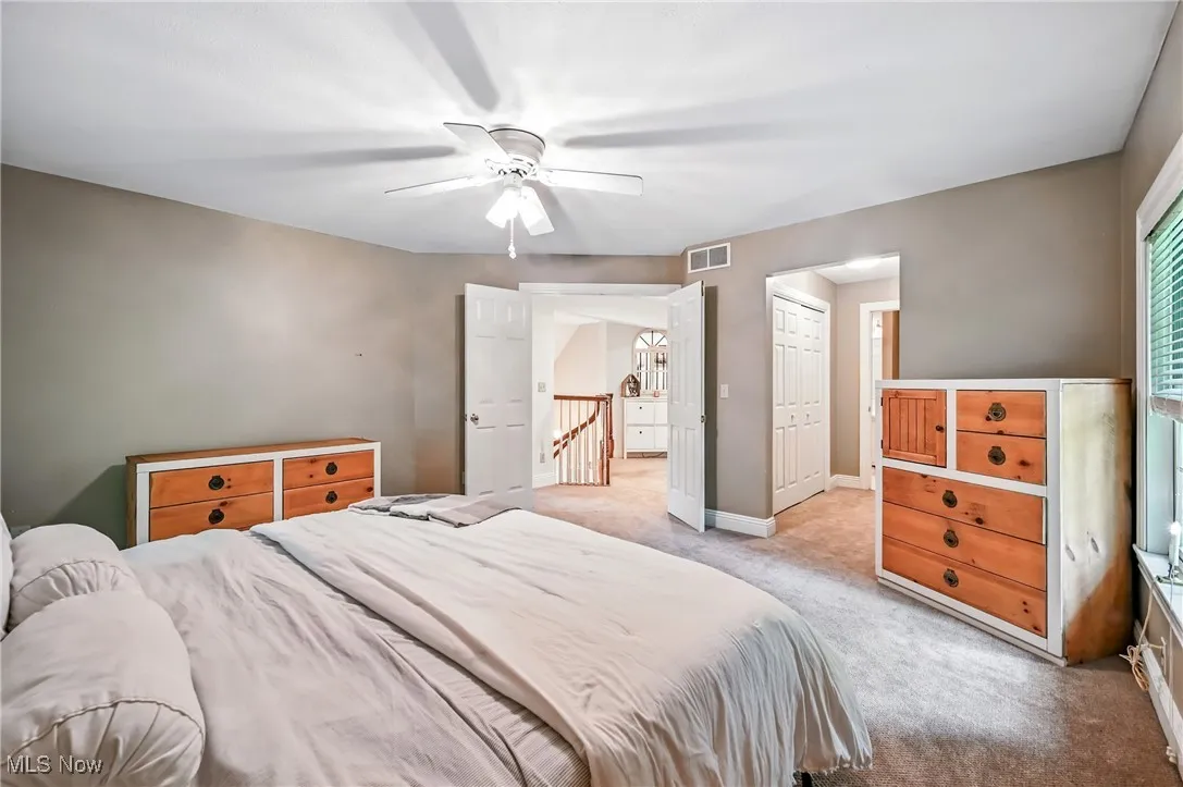 Bedroom with light carpet and ceiling fan