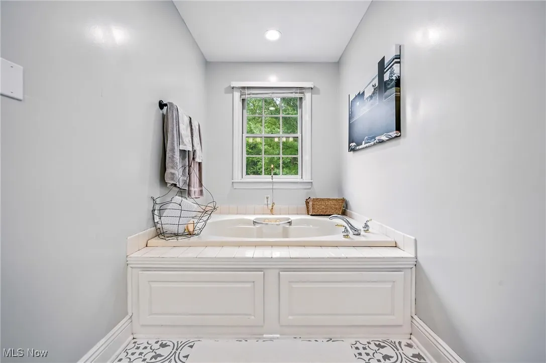 Bathroom with a garden tub and baseboards