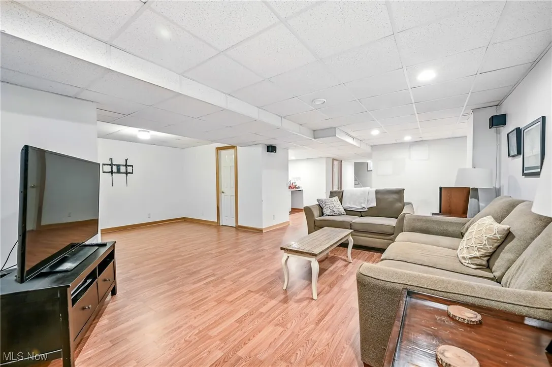 Living area with light wood-style floors, a drop ceiling, and recessed lighting