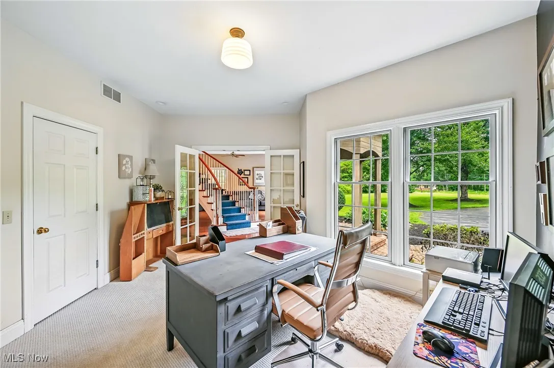 Home office with light colored carpet and baseboards