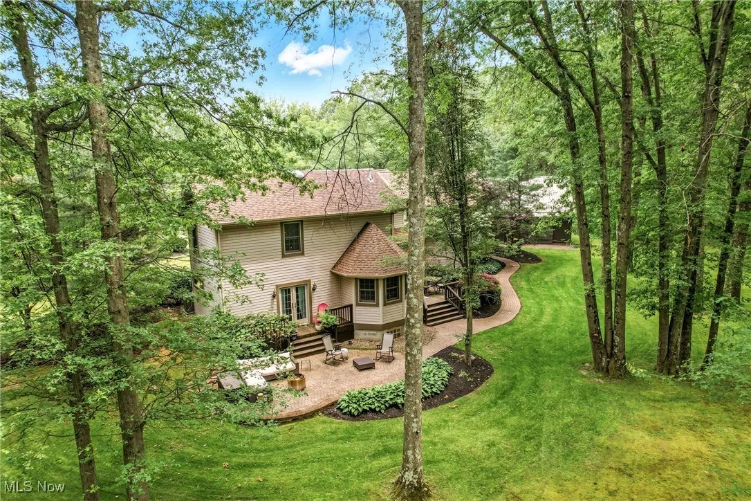 Back of house featuring french doors, a patio, a shingled roof, a lawn, and a wooden deck