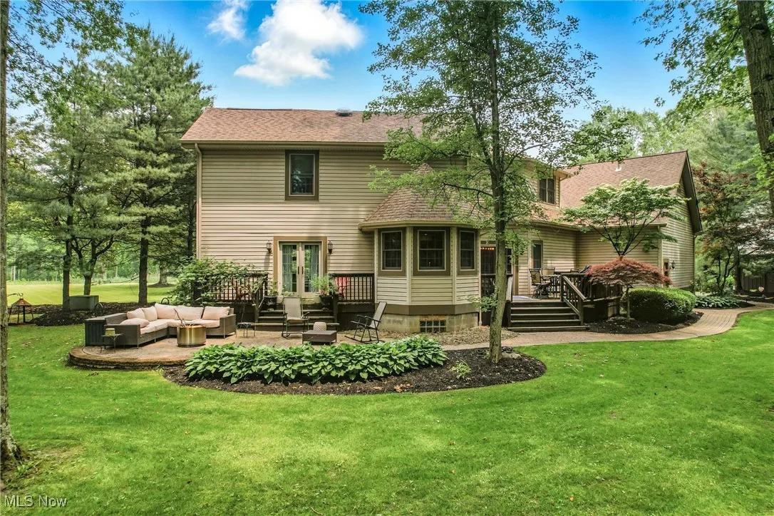Back of house featuring an outdoor living space, a deck, french doors, a lawn, and a patio area