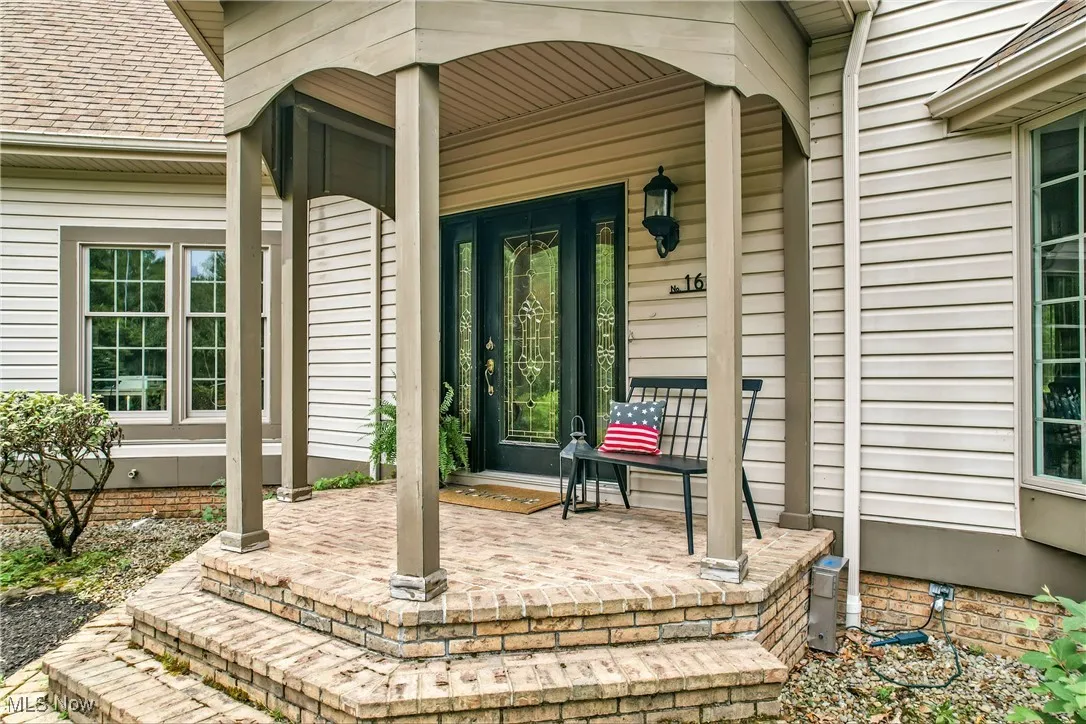 Property entrance featuring a porch and a shingled roof
