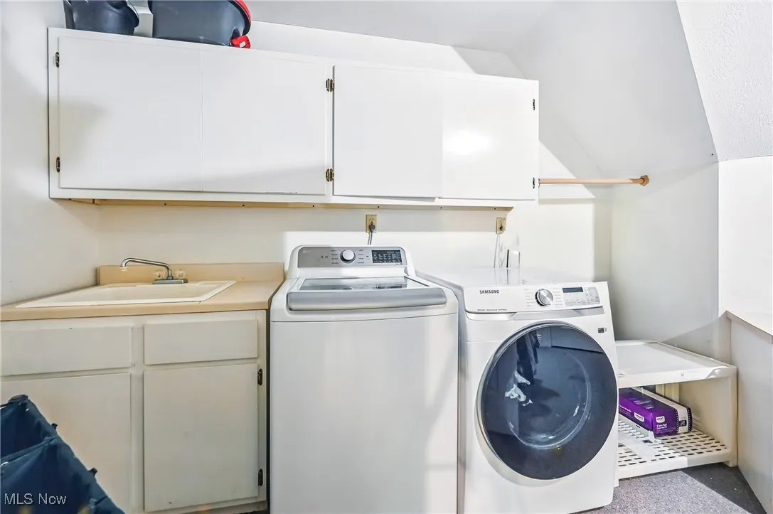Washroom featuring cabinet space, independent washer and dryer, and carpet