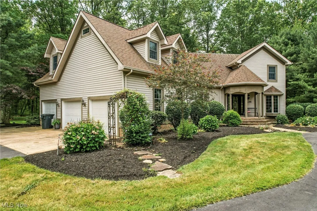 View of front of property with an attached garage, roof with shingles, concrete driveway, and a front yard