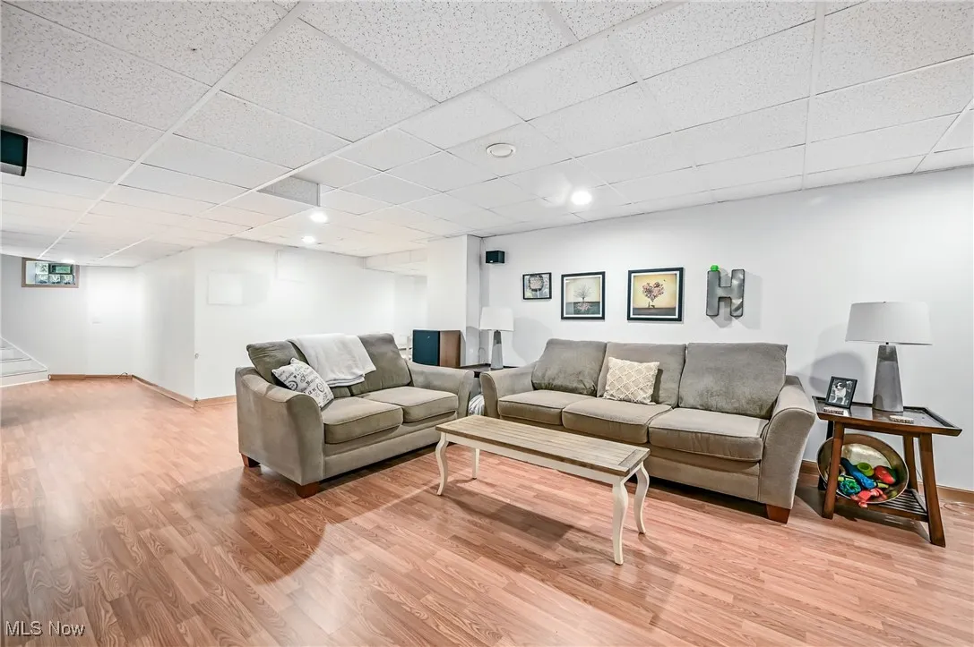 Living area with light wood finished floors, a drop ceiling, and recessed lighting