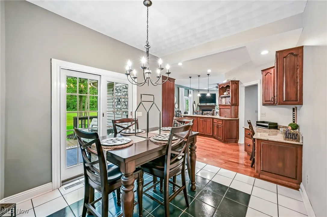 Dining space with plenty of natural light, a chandelier, light tile patterned flooring, and recessed lighting