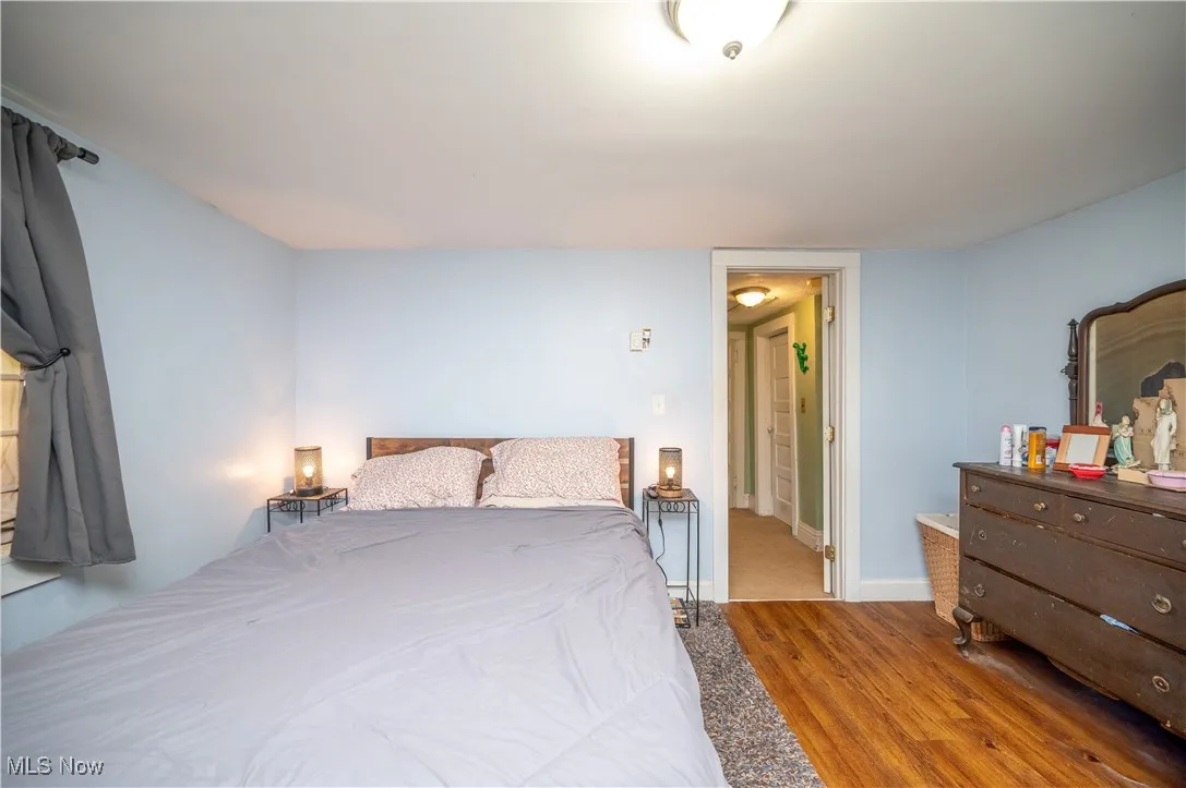 Bedroom with wood finished floors and baseboards