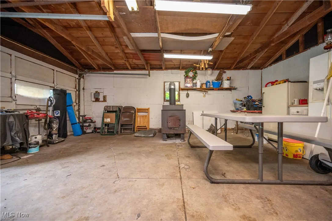 Garage with a wood stove and freestanding refrigerator