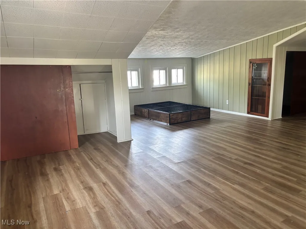 Spare room with wood finished floors and wood walls
