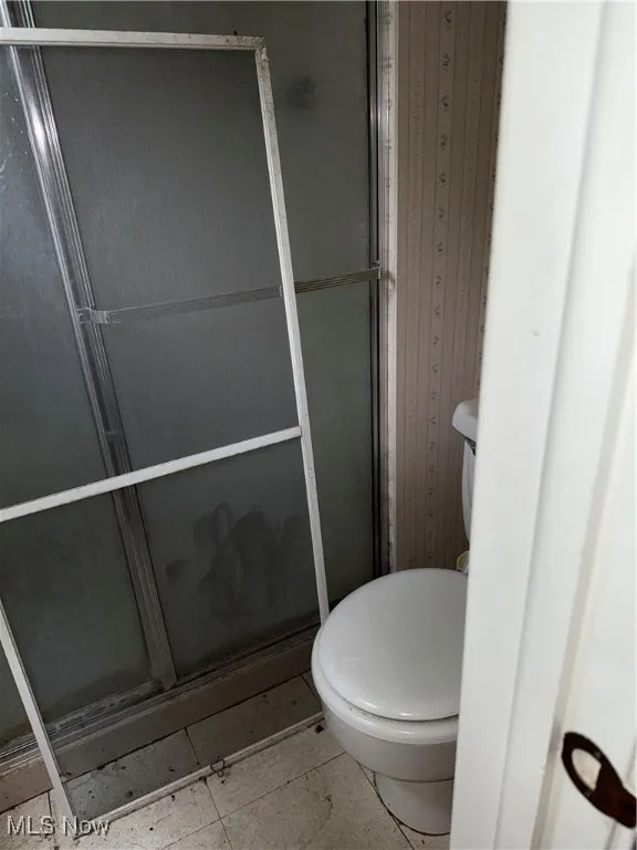 Full bath with toilet and a stall shower