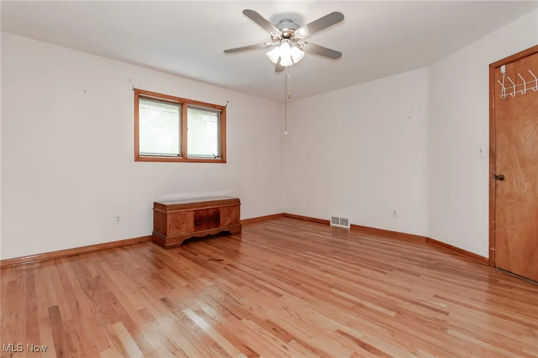 Empty room featuring light wood-style flooring and a ceiling fan