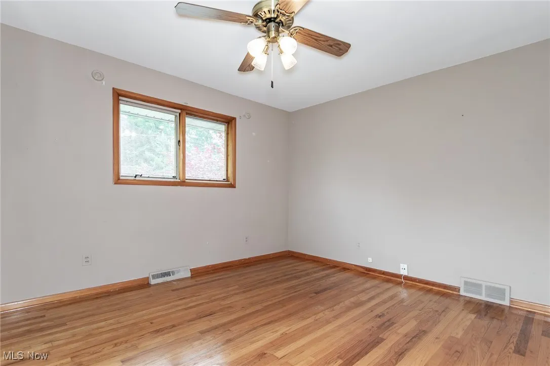 Unfurnished room featuring light wood-type flooring and ceiling fan