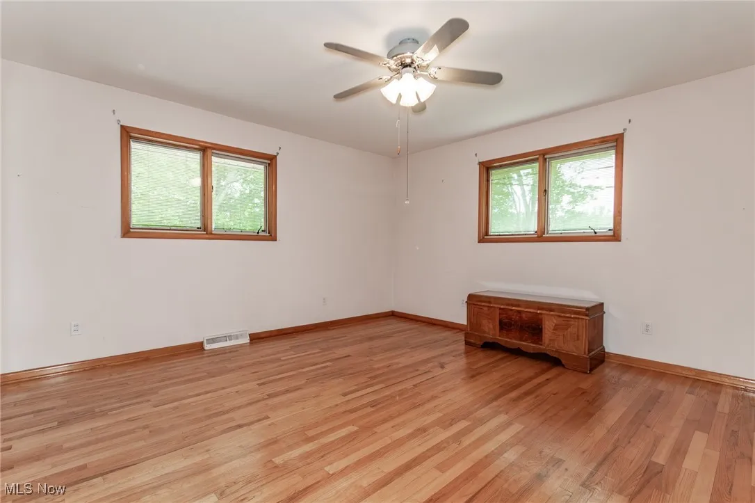 Spare room with plenty of natural light, light wood-style flooring, and ceiling fan