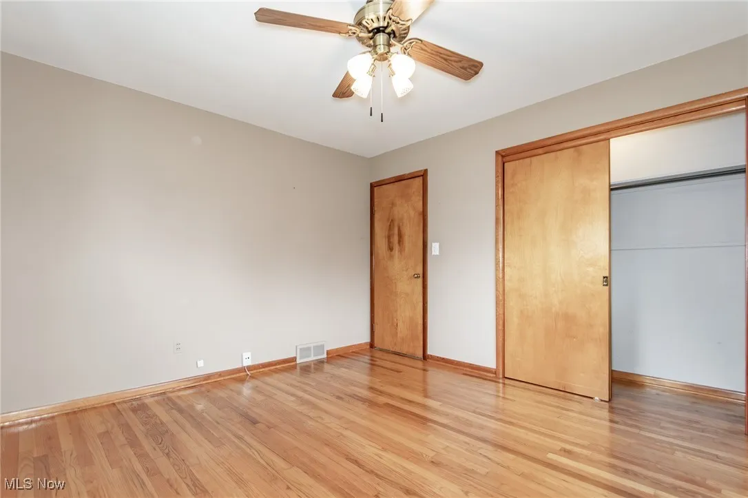 Unfurnished bedroom featuring light wood-type flooring, a closet, and a ceiling fan