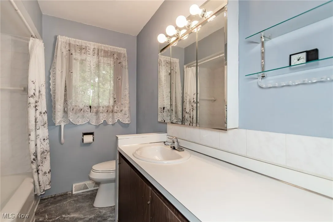 Full bath with vanity, shower / bath combo, and a chandelier