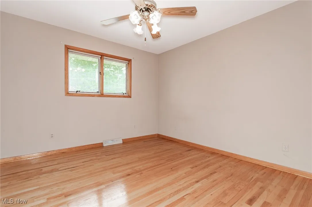 Spare room featuring ceiling fan and light wood-style floors