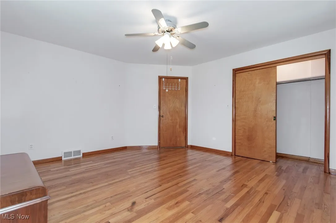 Unfurnished bedroom with light wood finished floors and ceiling fan