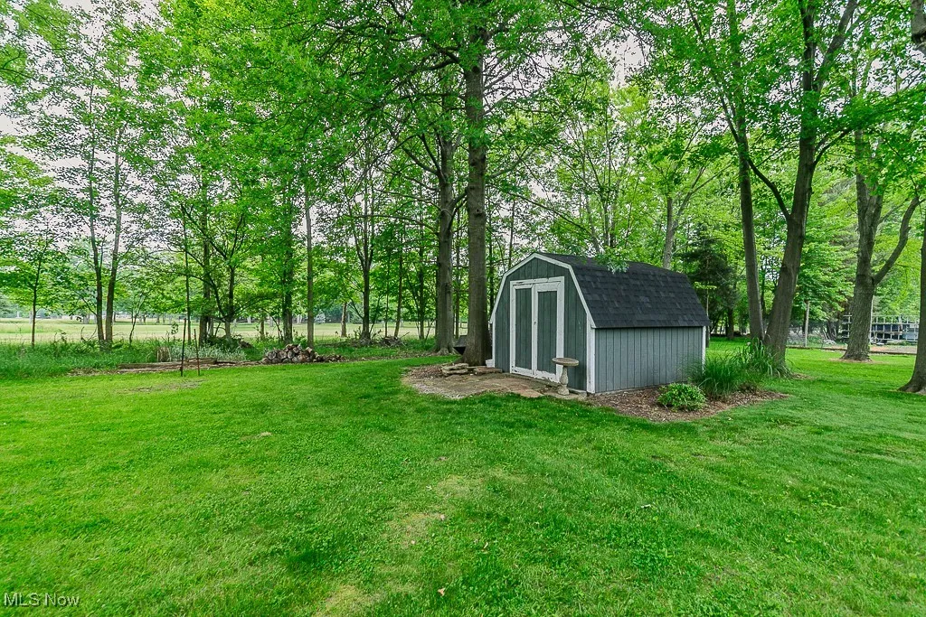 View of green lawn featuring a shed