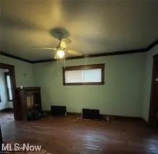 Unfurnished living room featuring a ceiling fan