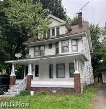American foursquare style home with covered porch and a chimney
