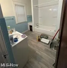 Full bath with wood finished floors, bathtub / shower combination, and vanity