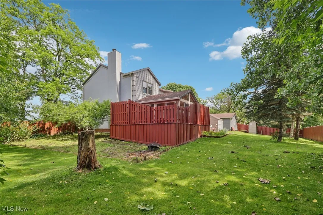 View of yard with garden area and 2 mature peach trees