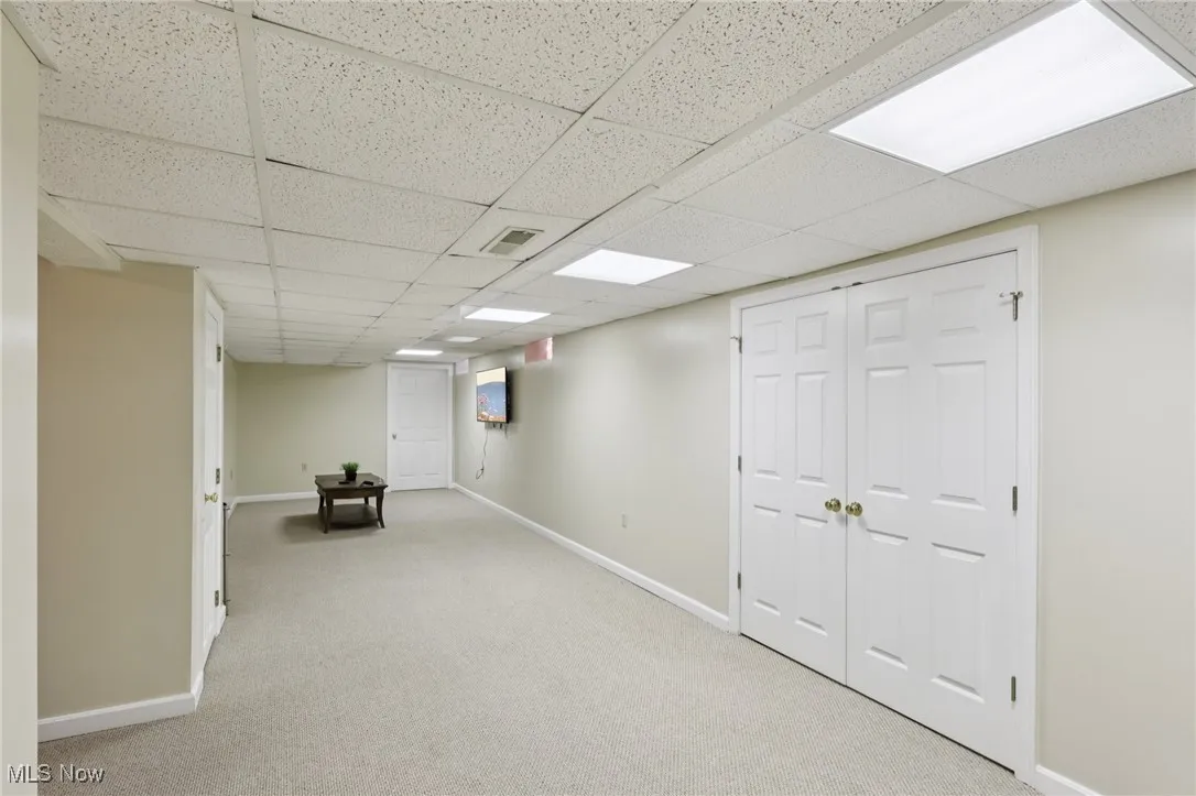 Finished basement featuring carpet floors and a drop ceiling