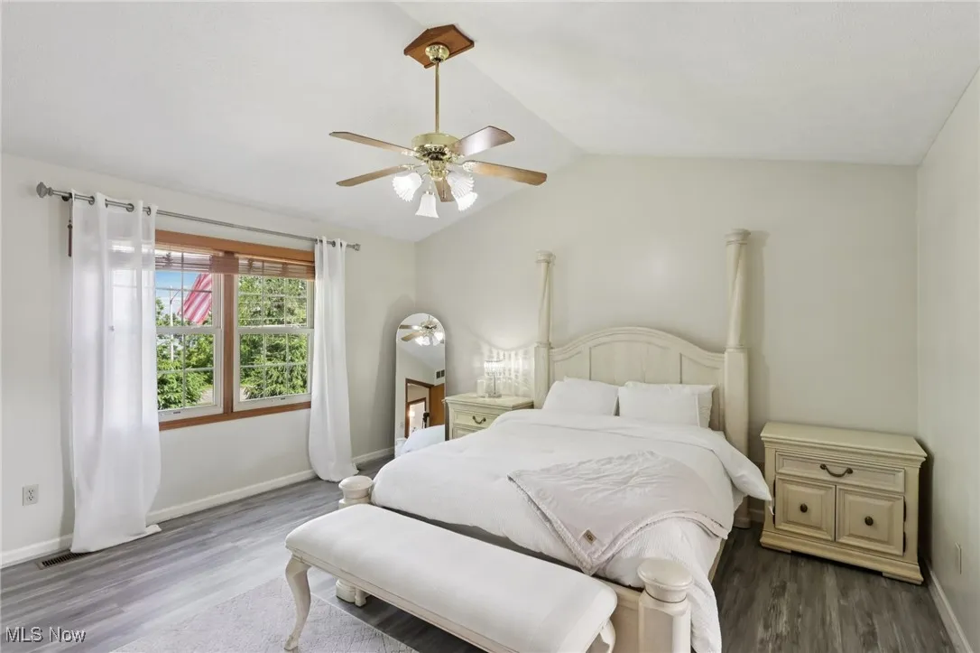 Master Bedroom featuring vaulted ceiling, wood floors, and a ceiling fan