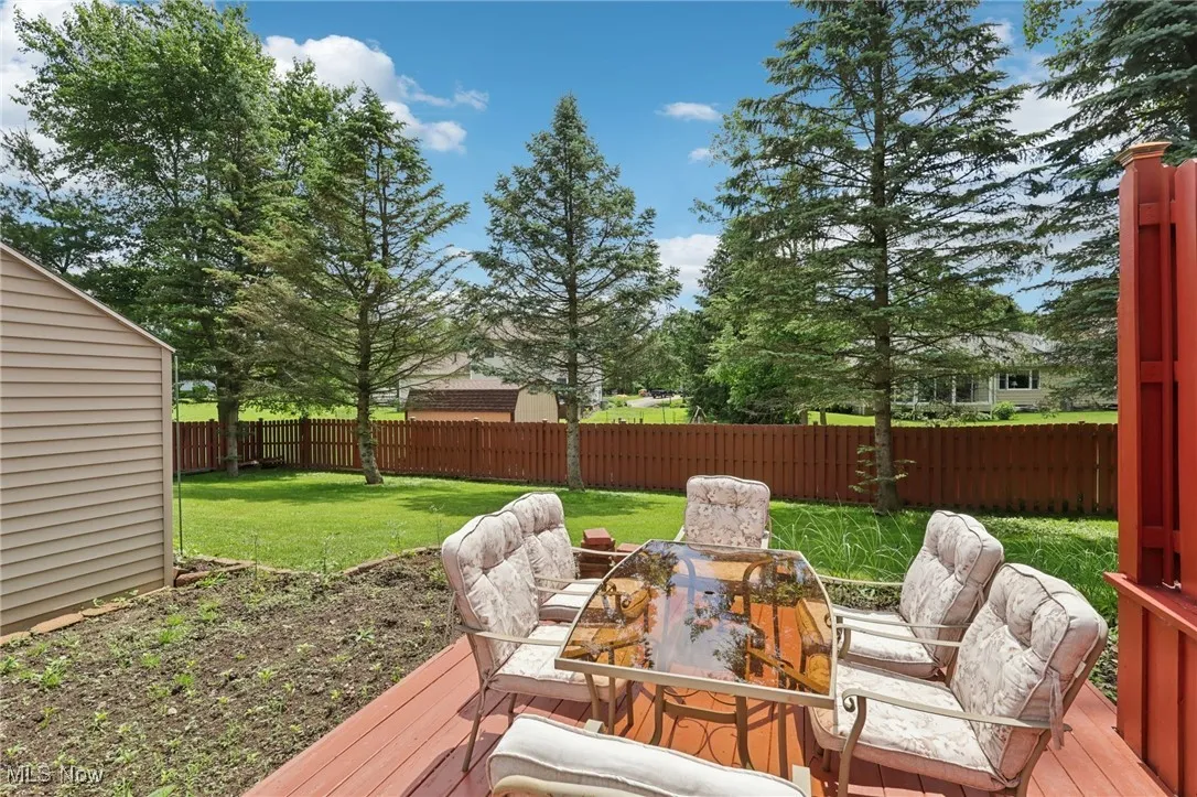 Wooden deck with a fenced backyard and outdoor dining area
