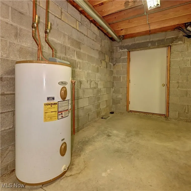 Unfinished below grade area featuring water heater