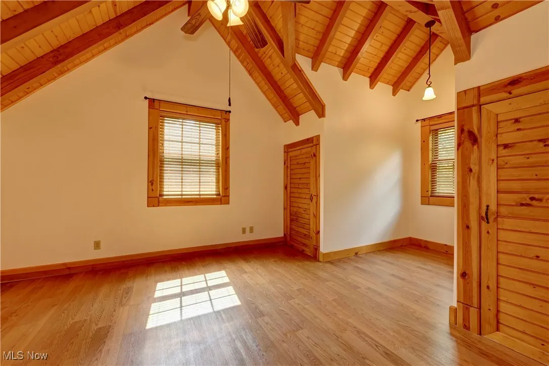 Unfurnished living room with wood ceiling, a ceiling fan, and light wood-type flooring