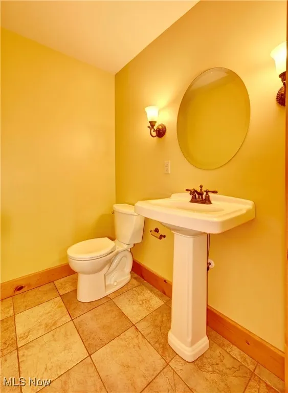 Half bath with toilet and baseboards