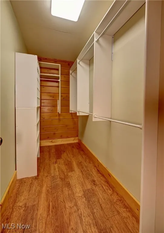 Walk in closet with wood finished floors