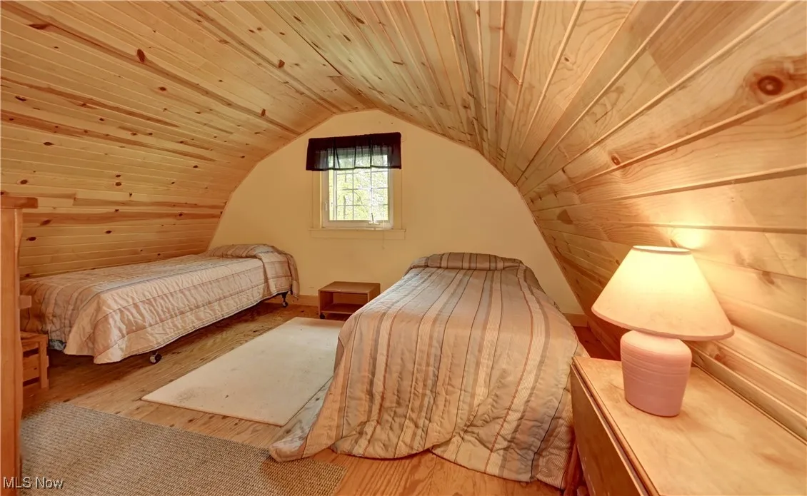 Bedroom featuring wood finished floors, vaulted ceiling, and wood ceiling