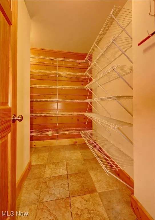 Spacious closet with light stone finish floors