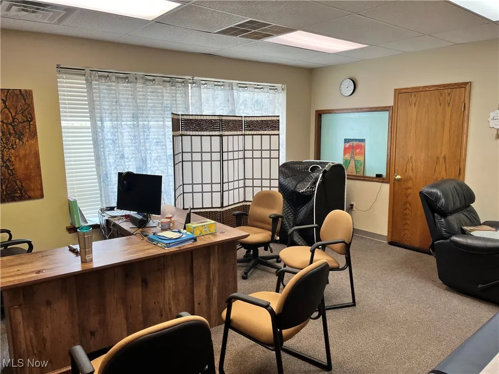 Office space with a paneled ceiling and carpet flooring