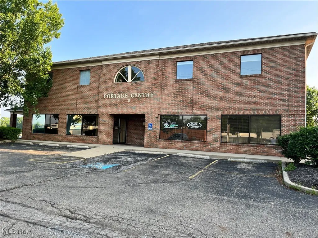 View of building exterior featuring uncovered parking