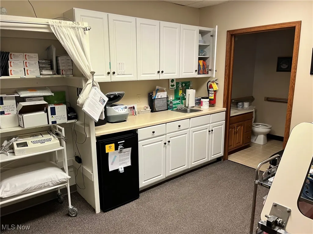 Kitchen featuring white cabinets, light countertops, and open shelves