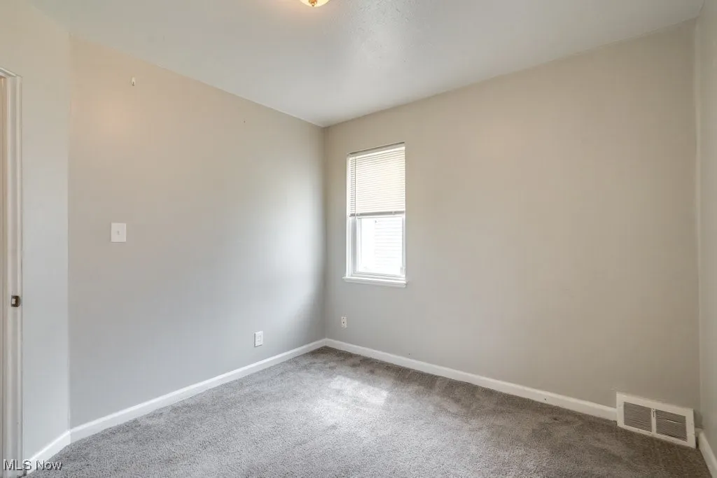 Carpeted empty room with baseboards