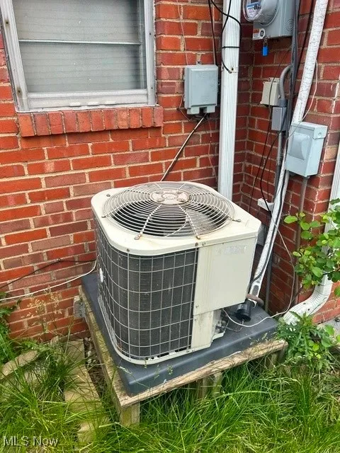 Exterior view of a central AC unit and brick siding