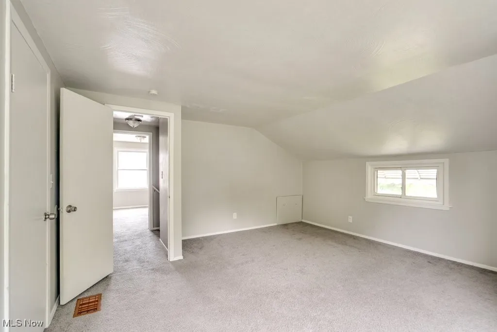 Bonus room featuring carpet, healthy amount of natural light, and lofted ceiling