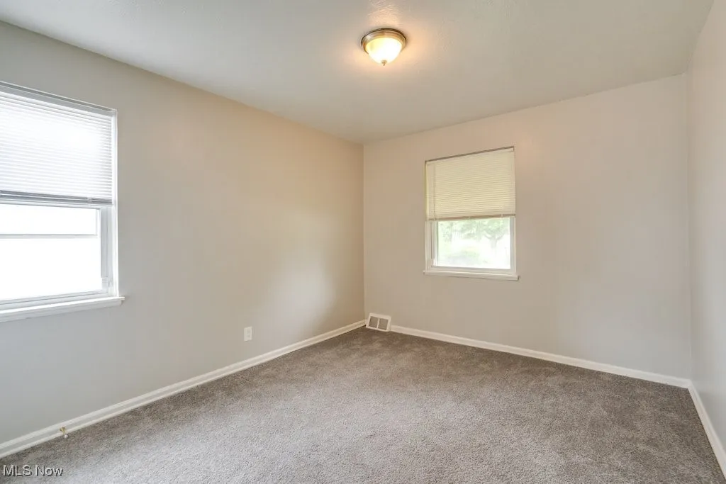 Unfurnished room featuring carpet and baseboards