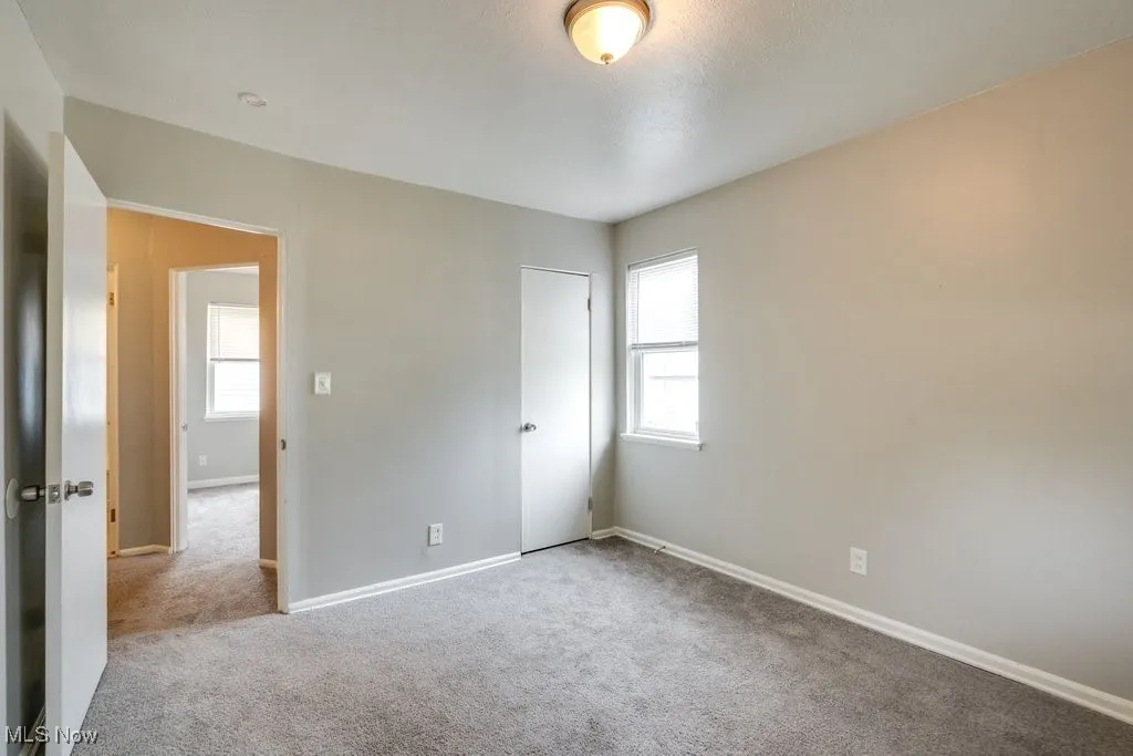 Carpeted empty room featuring baseboards