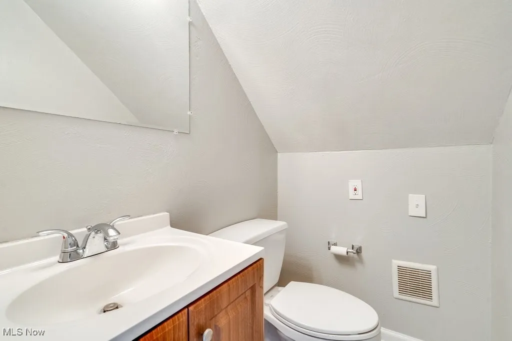 Bathroom featuring vaulted ceiling and vanity