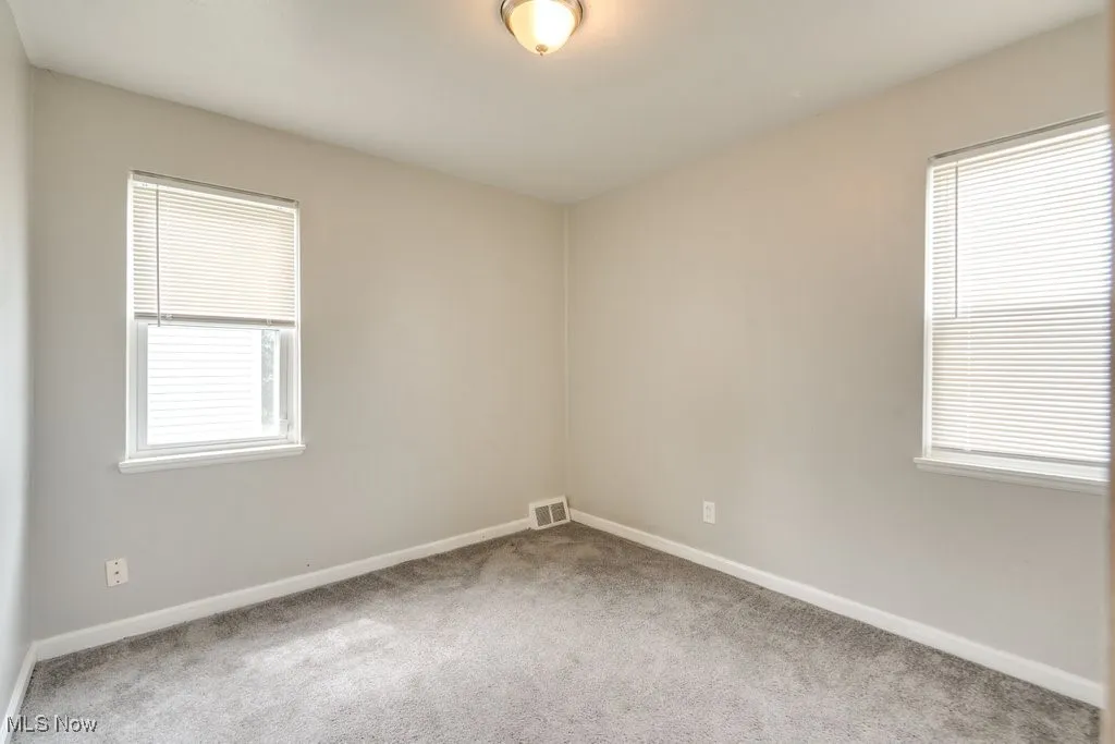 Carpeted empty room featuring baseboards