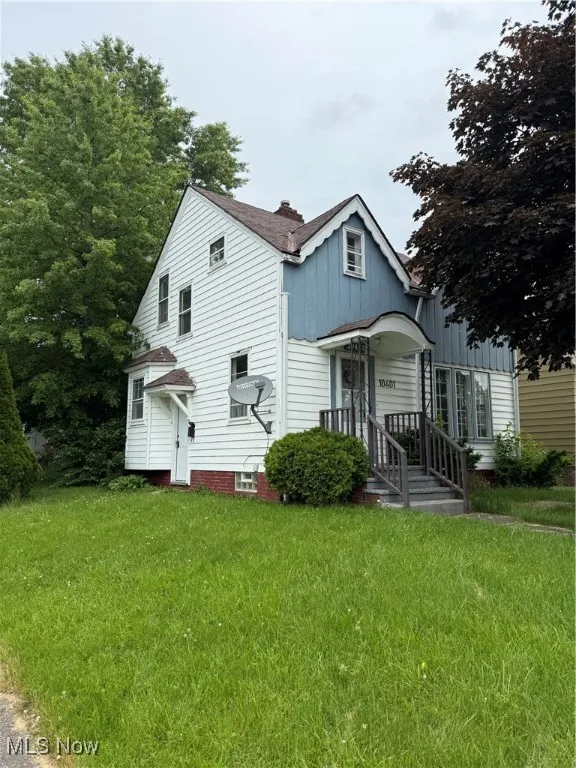 Rear view of property featuring board and batten siding, a lawn, and a chimney