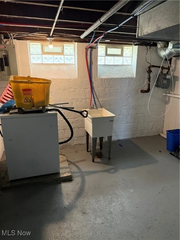 Basement with electric panel and a sink